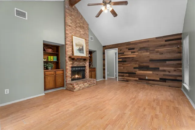 a view of a livingroom with a fireplace a chandelier and stairs