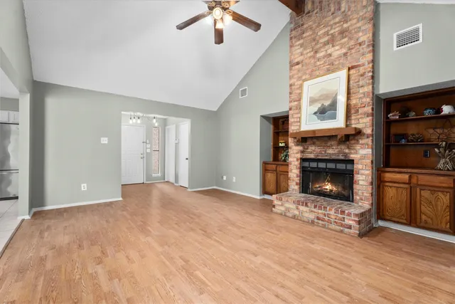 a view of an empty room with a fireplace and a window