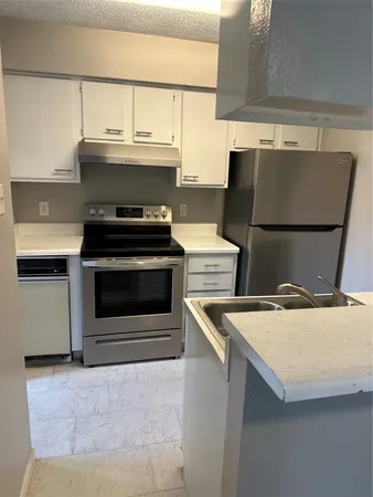 a stove top oven sitting inside of a kitchen