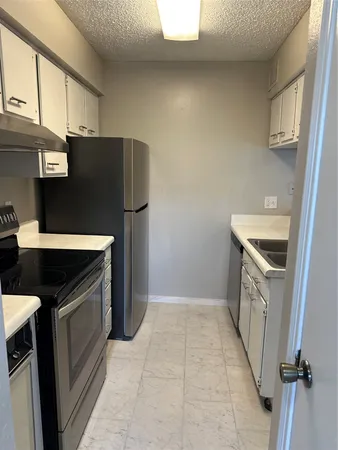 a kitchen with a stove top oven and cabinets