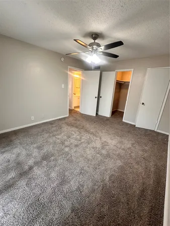 an empty room with a ceiling fan and window
