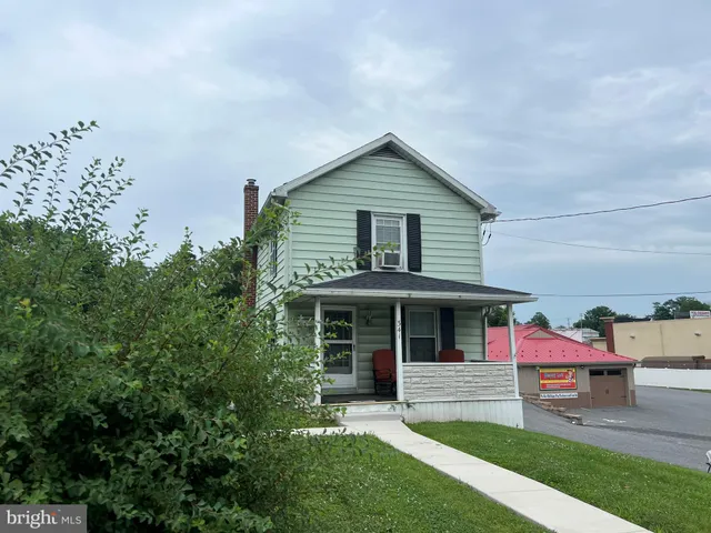 a view of a house with a yard and potted plants