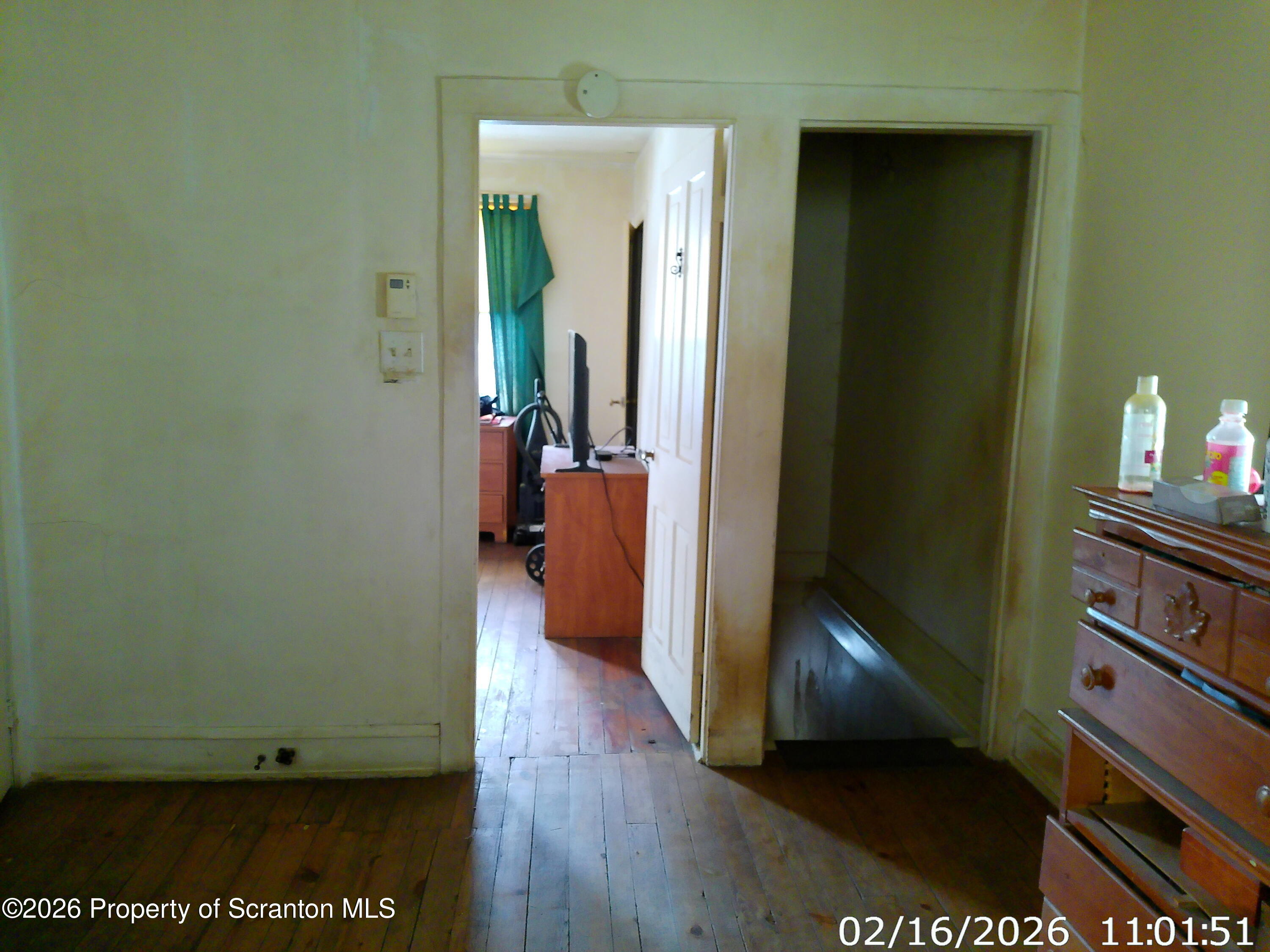 319 South 9th Avenue Scranton, PA 18504 - Photo 23 of 49 a view of a hallway with wooden floor and a livingroom with furniture