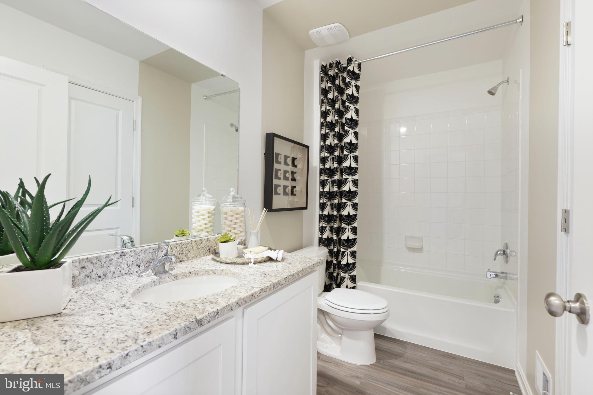 1271 Apollo Drive Frederick, MD 21702 - Photo 21 of 35 a bathroom with a granite countertop toilet a sink and a bathtub