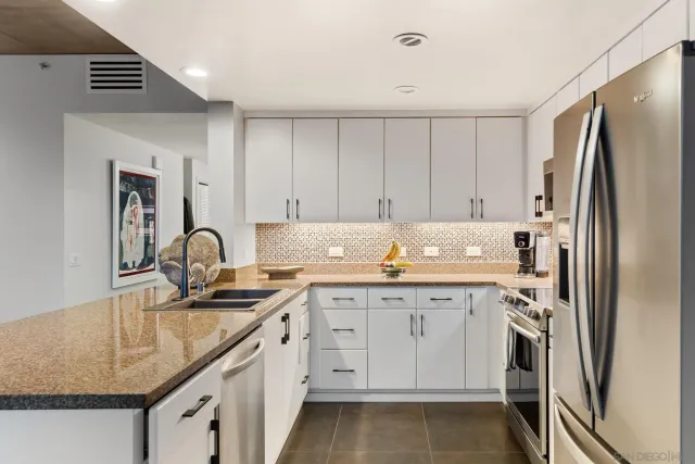 a kitchen with stainless steel appliances granite countertop a sink and a refrigerator