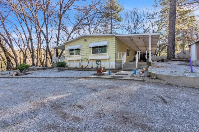 a view of a house with backyard and trees