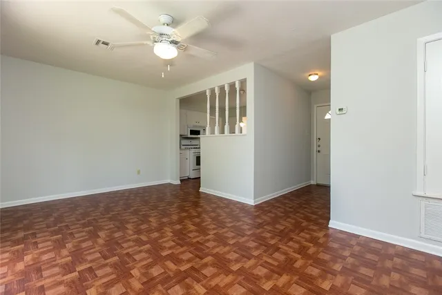 an empty room with closet and a ceiling fan