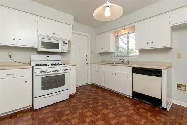 a kitchen with granite countertop a stove a sink and a microwave
