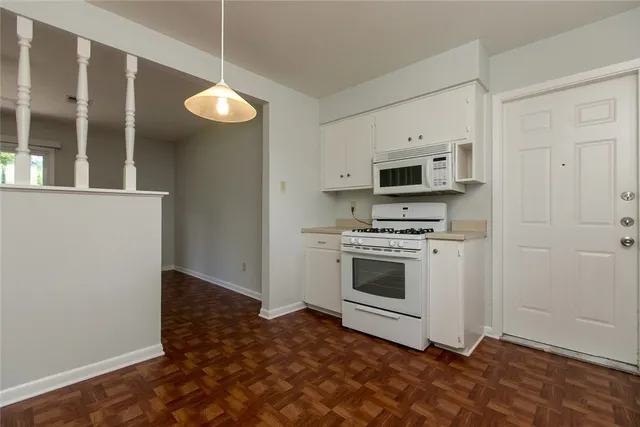 a kitchen with granite countertop a stove a microwave and a refrigerator