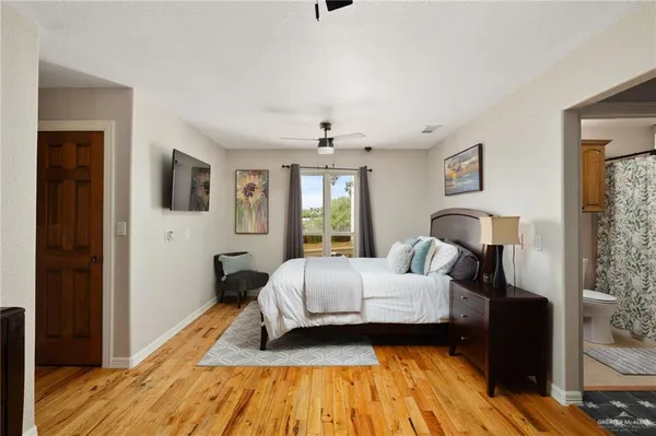 a view of a hallway with wooden floor and chandelier