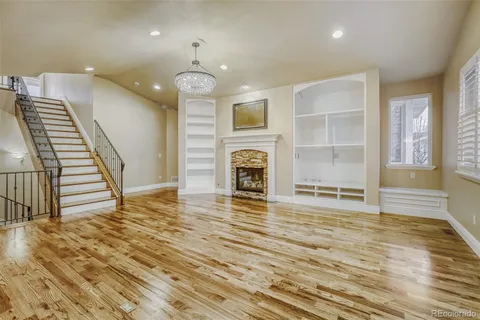 an empty room with wooden floor and fireplace