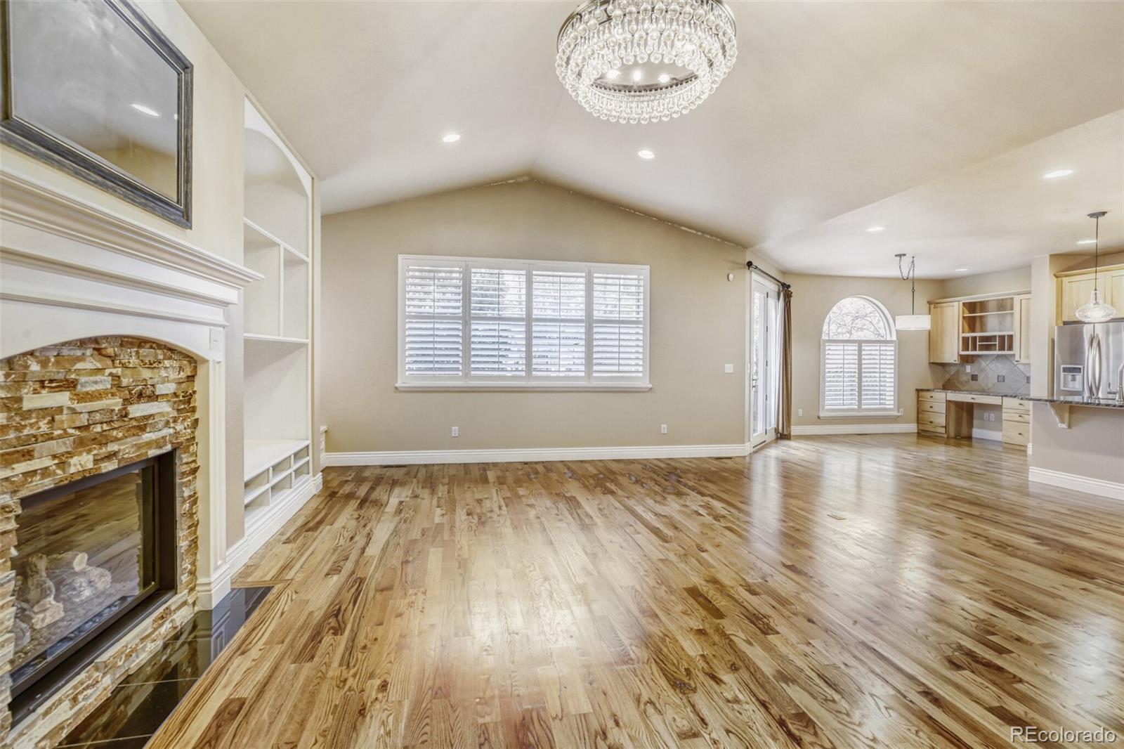 940 Kearney Street Denver, CO 80220 - Photo 15 of 49 an empty room with wooden floor a fireplace and windows
