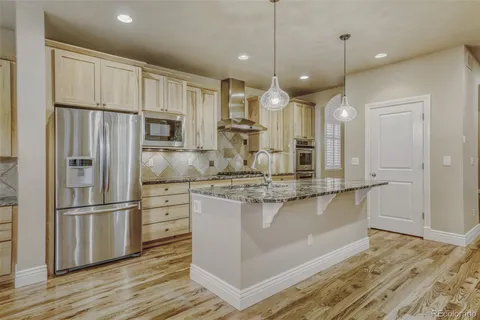 a kitchen with kitchen island white cabinets and stainless steel appliances