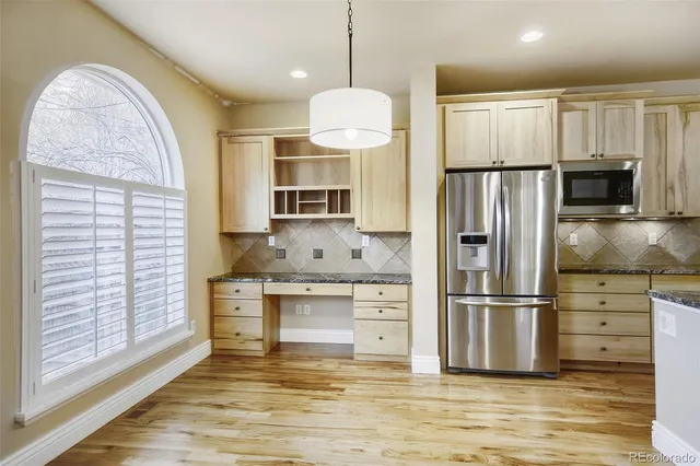 a kitchen with stainless steel appliances granite countertop a refrigerator and a stove top oven