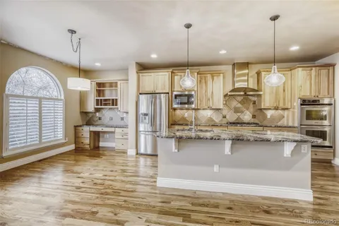 a kitchen with stainless steel appliances granite countertop a stove sink and refrigerator