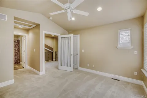 an empty room with closet and a ceiling fan