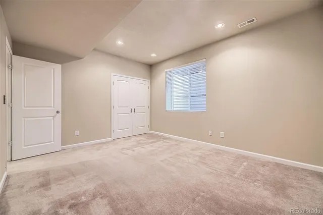 an empty room with windows and closet