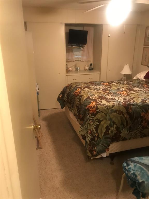 11076 100th Street, Unit 41 Largo, FL 33773 - Photo 12 of 17 a bedroom with a bed and a flat screen tv