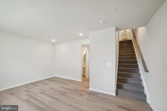 a view of hallway with stairs and wooden floor