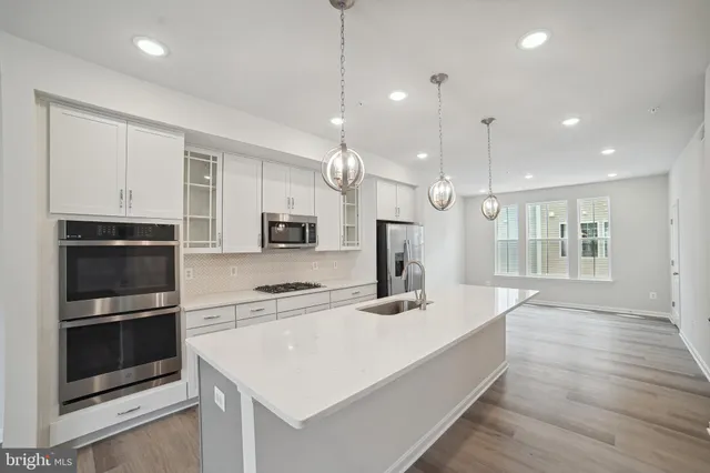 a large kitchen with kitchen island a sink stainless steel appliances and cabinets