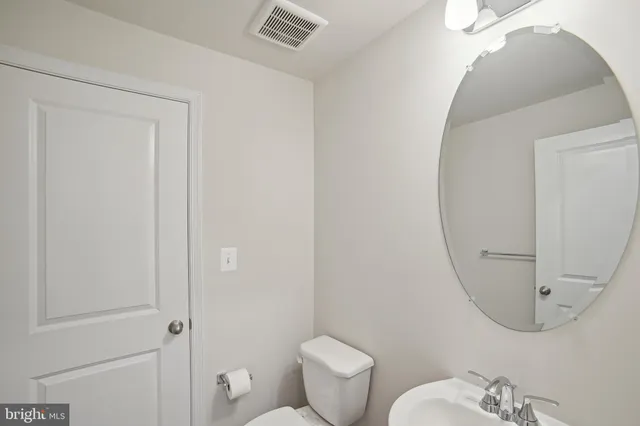 a bathroom with a toilet and a mirror