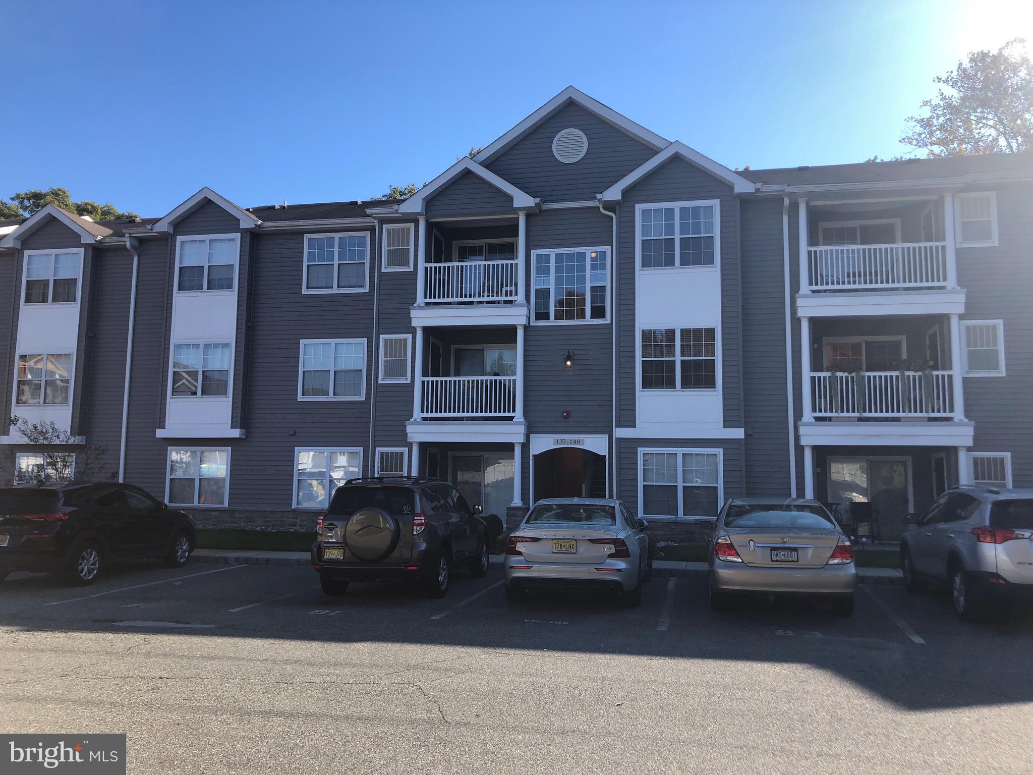 a front view of a residential apartment building with a yard
