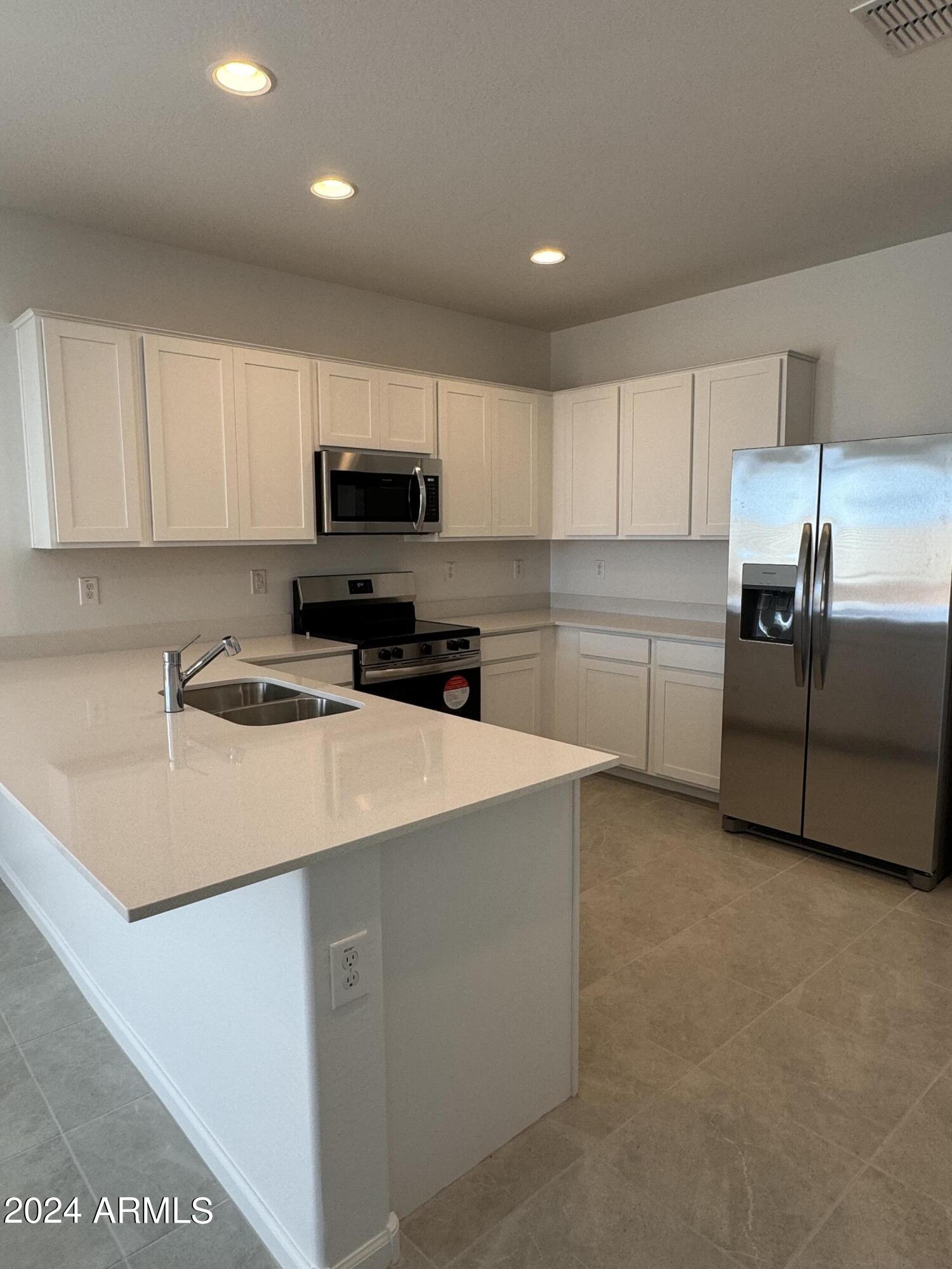 12088 East Verbina Lane Florence, AZ 85132 - Photo 6 of 48 a kitchen with stainless steel appliances a stove a sink a microwave a refrigerator and cabinets