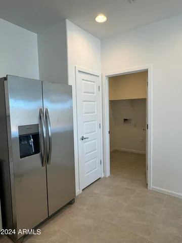 a view of a refrigerator in kitchen and a kitchen