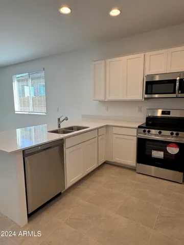 a kitchen with stainless steel appliances a sink stove and microwave