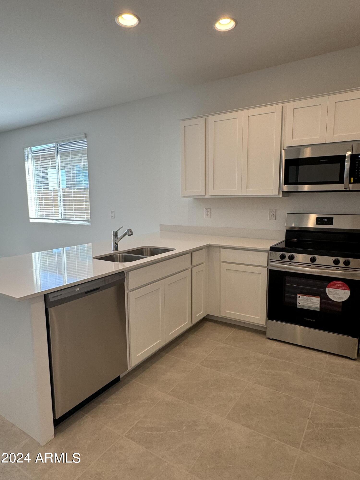 12088 East Verbina Lane Florence, AZ 85132 - Photo 9 of 48 a kitchen with stainless steel appliances a sink stove and microwave