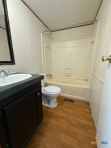 a bathroom with a sink a toilet a mirror and shower