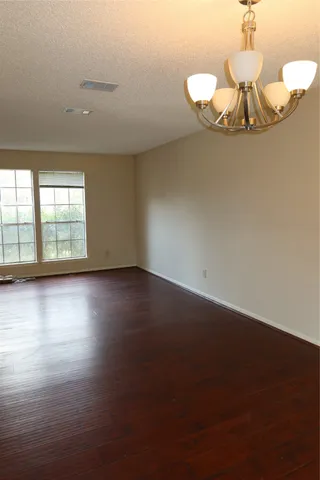 a view of wooden floor and chandelier in a room