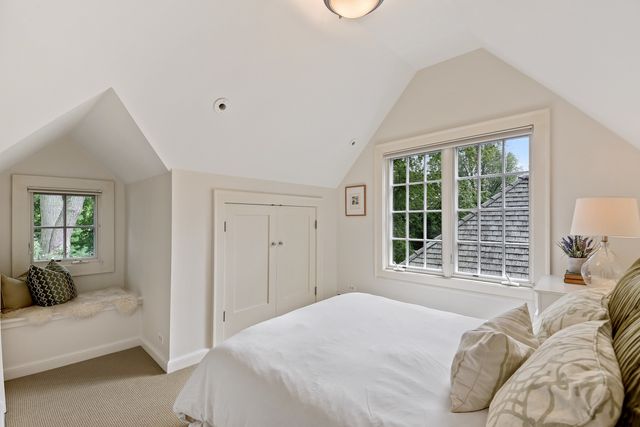 a bedroom with a bed and a large window