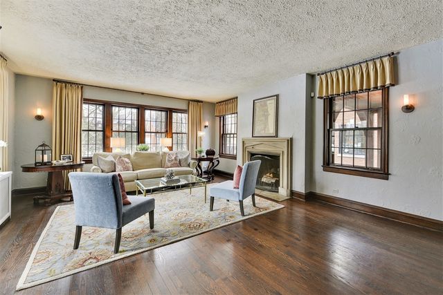 a living room with fireplace furniture and a window