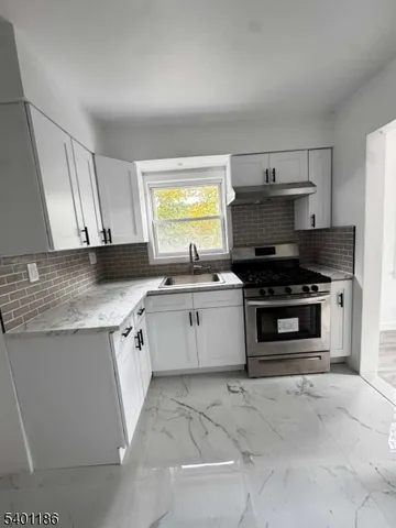 a kitchen with stainless steel appliances a stove a sink and a microwave