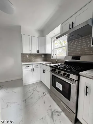 a kitchen with a stove a sink and a window