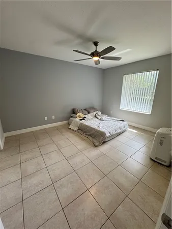 a bedroom with a bed and a ceiling fan