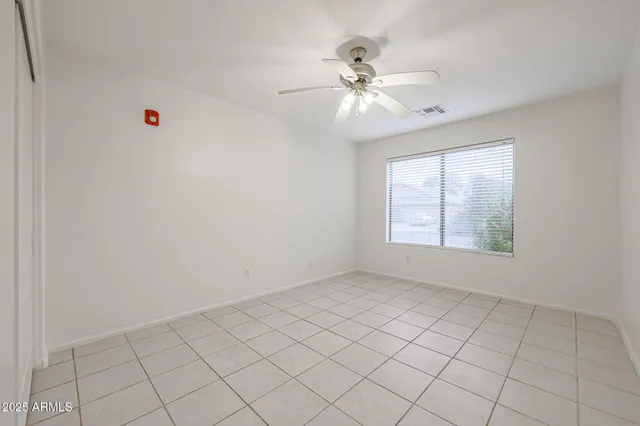 a view of an empty room and chandelier fan
