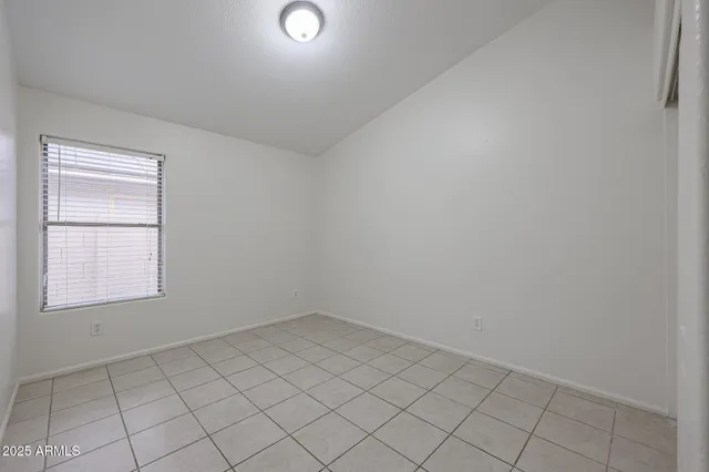 an empty room with a white cabinet and a window