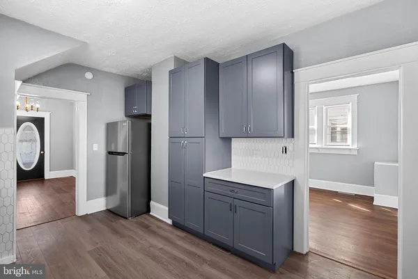 a kitchen with stainless steel appliances granite countertop a refrigerator a sink dishwasher a stove with wooden floor and cabinets