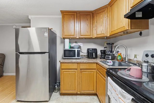 a kitchen with stainless steel appliances granite countertop a refrigerator and a sink