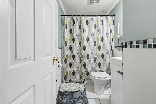 a bathroom with a toilet and a shower curtain