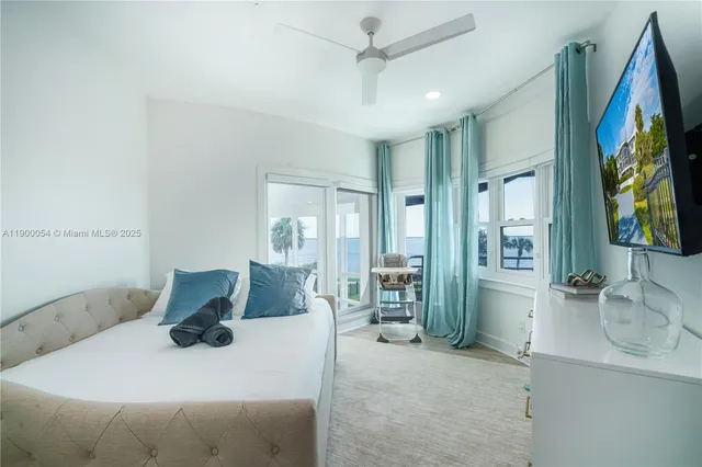 a view of a patio with couches a table and chairs with wooden floor and fence
