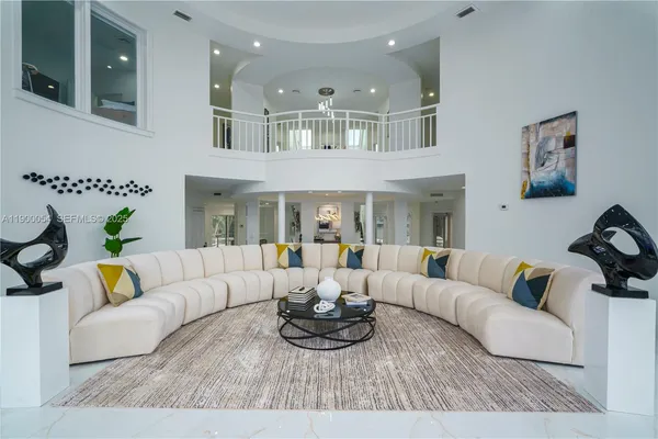 a living room with furniture and floor to ceiling windows
