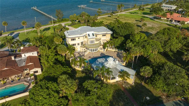 a view of balcony with two chairs potted plants and a palm tree