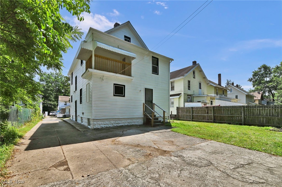 732 Carpenter Street Akron, OH 44310 - Photo 36 of 38 Rear view of property featuring driveway, a balcony, a chimney, and entry steps