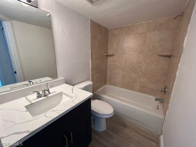 1555 Blue Point Avenue, Unit 2 Naples, FL 34102 - Photo 8 of 10 Full bathroom with vanity, hardwood / wood-style flooring, toilet, and tiled shower / bath