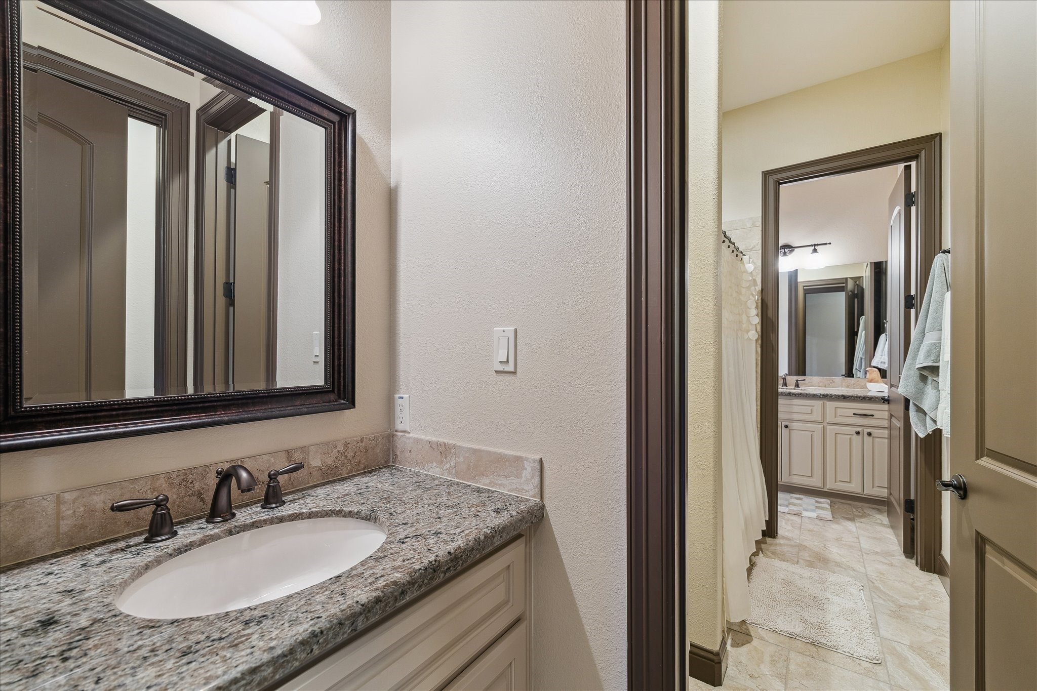 11 Willowcreek Ranch Road Tomball, TX 77377 - Photo 34 of 49 This Hollywood bath features separate sink areas with granite counters and oil rubbed bronze hardware. They share the adjoining water closet, tub, and shower combination.