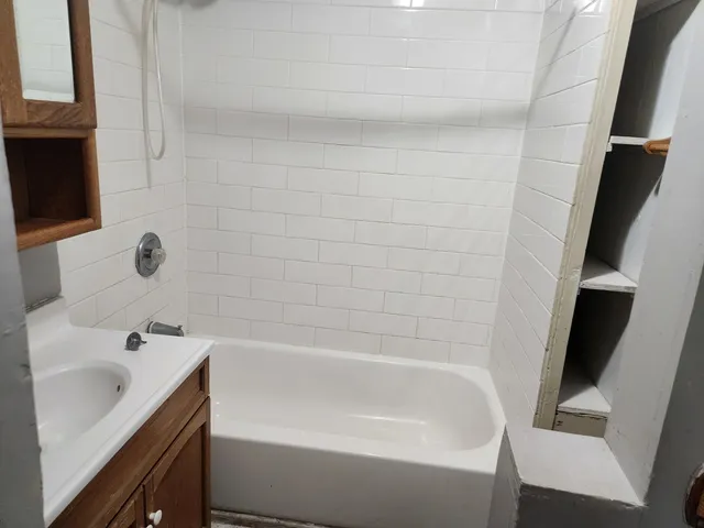 a white bath tub sitting next to a white sink