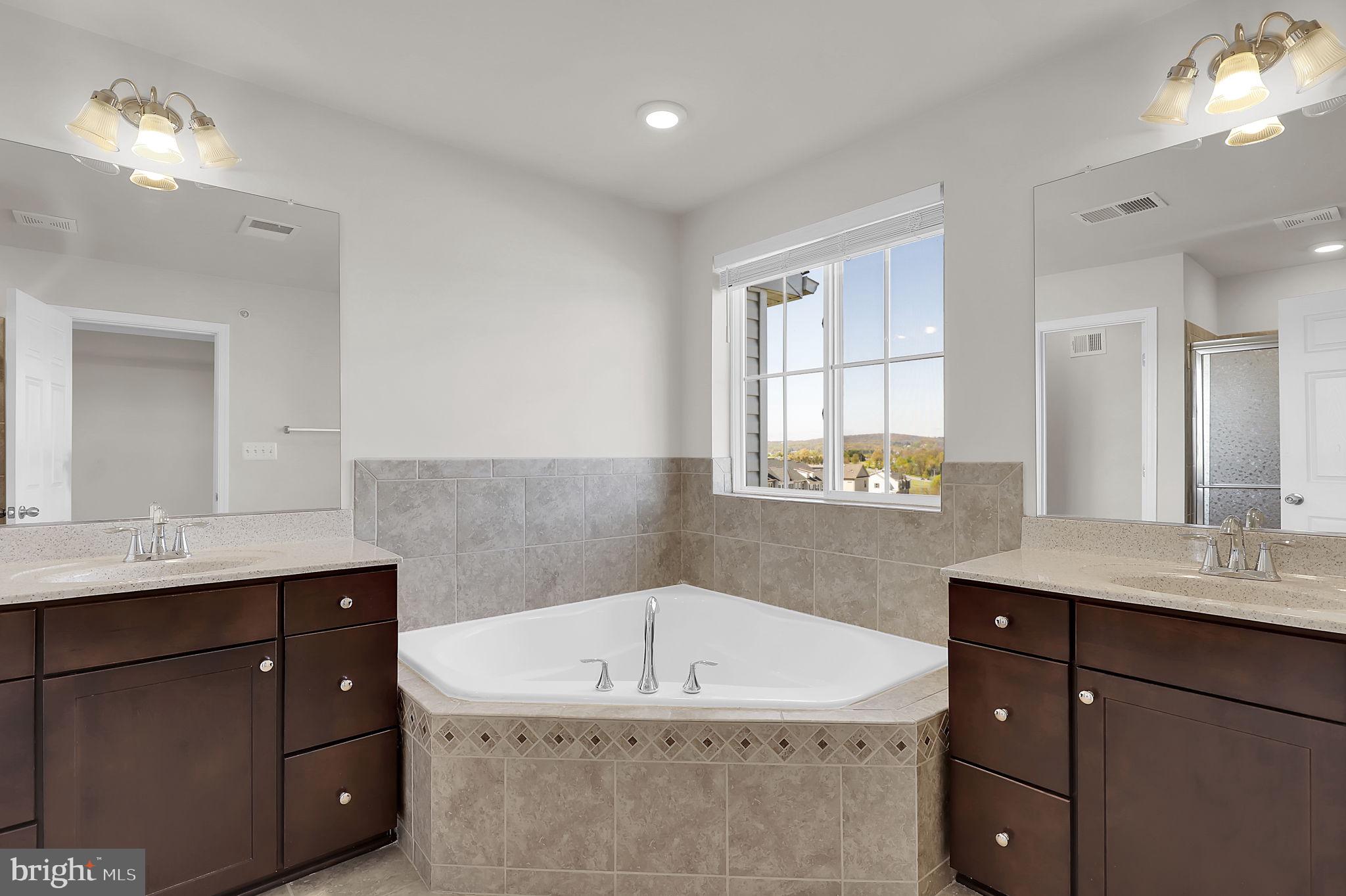 5906 Krantz Drive Frederick, MD 21703 - Photo 24 of 40 a bathroom with a sink double vanity granite tub shower and a mirror